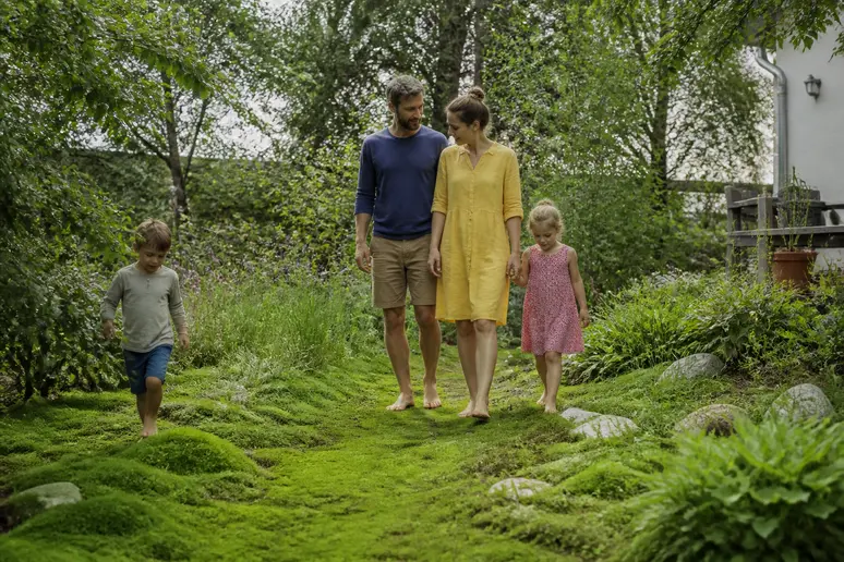 Familie genießt den Garten mit Sternmoos als Rasenersatz in Deutschland.